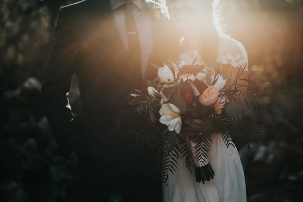 A newlywed couple with a wedding bouquet